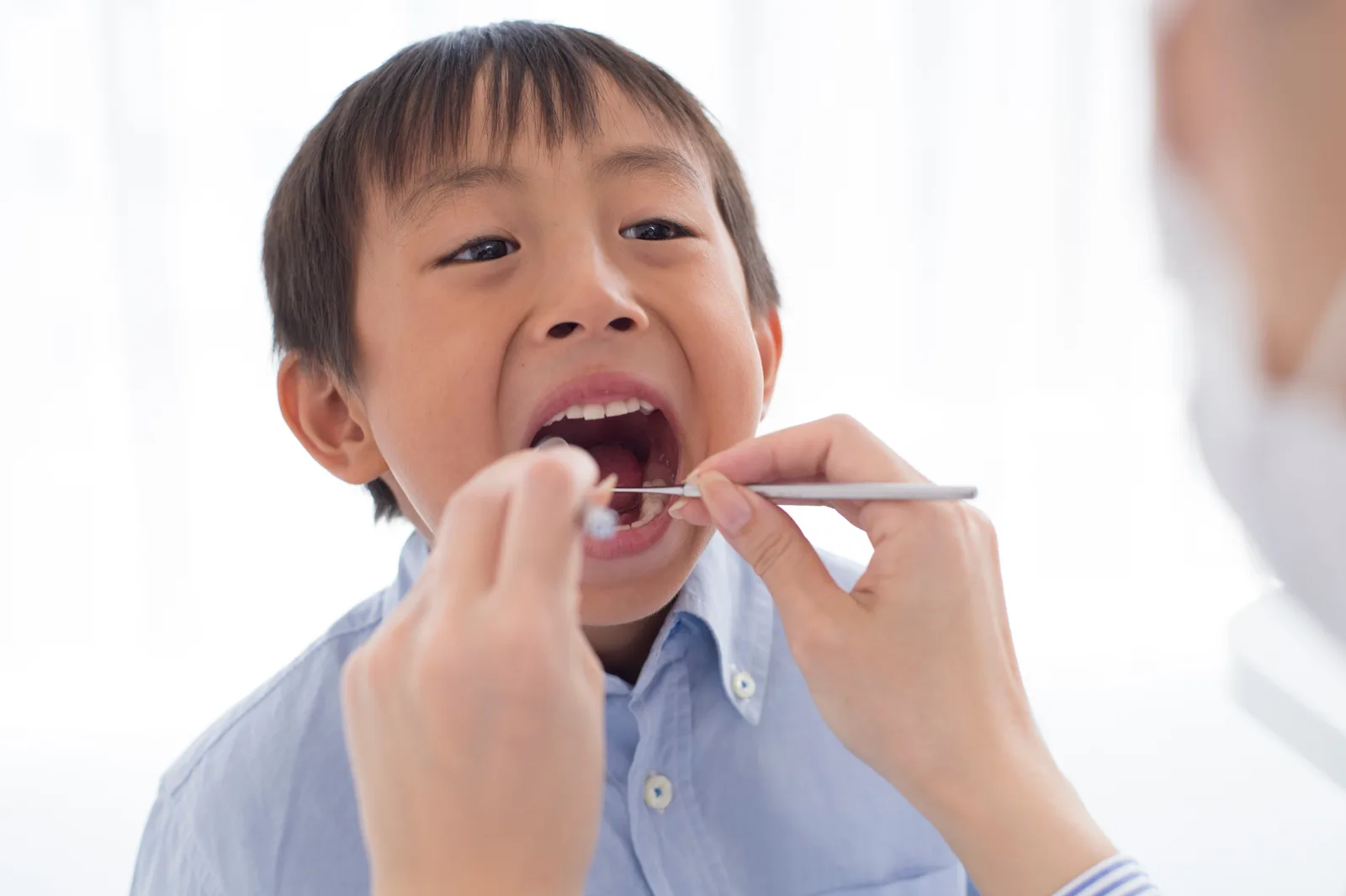 落ち着いて口の中を診てもらう男の子
